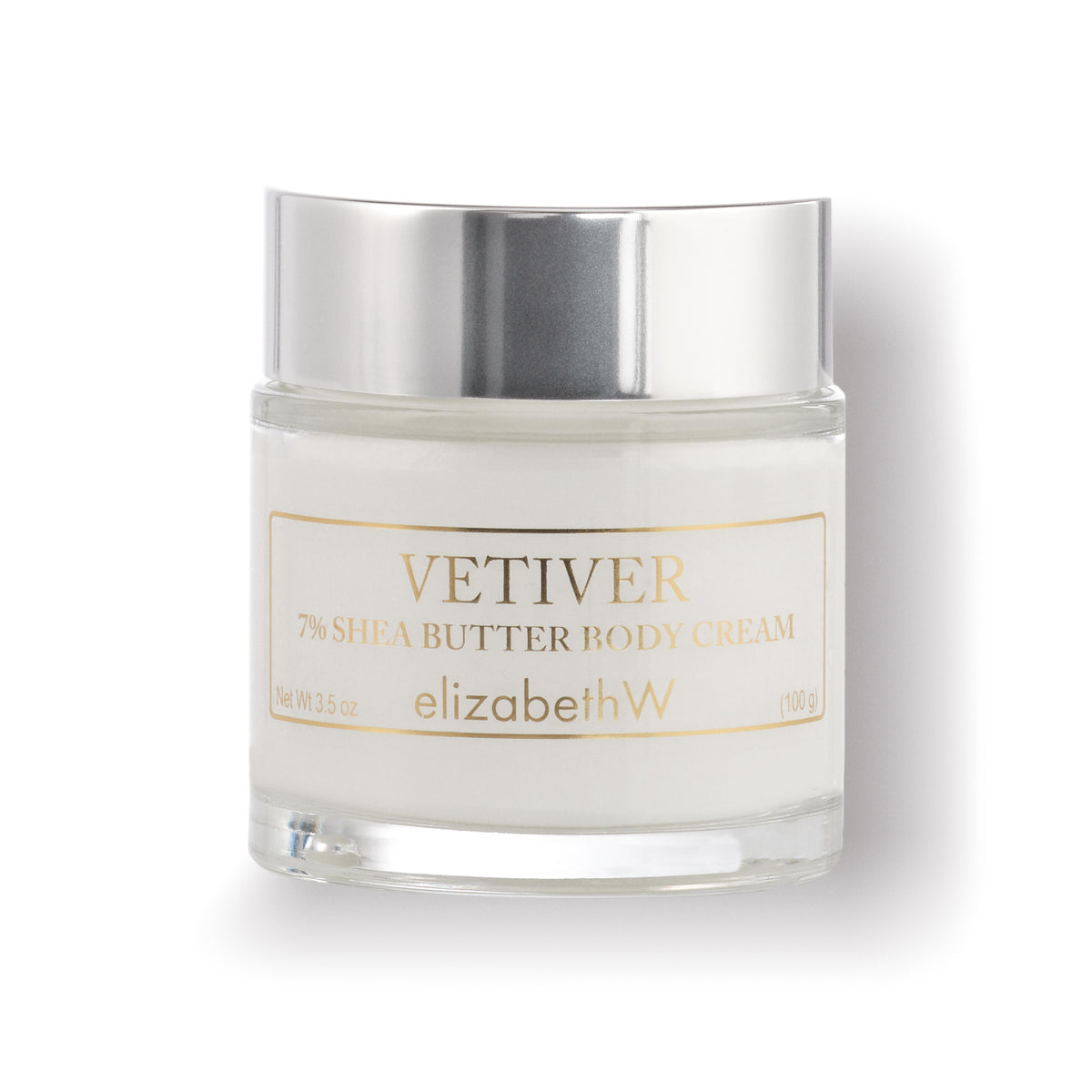 A 3.5 oz (100 g) clear glass jar filled with body cream. The jar has a silver lid, and the label reads &quot;Vetiver 7% Shea Butter Body Cream&quot; with the elizabethW brand name below.